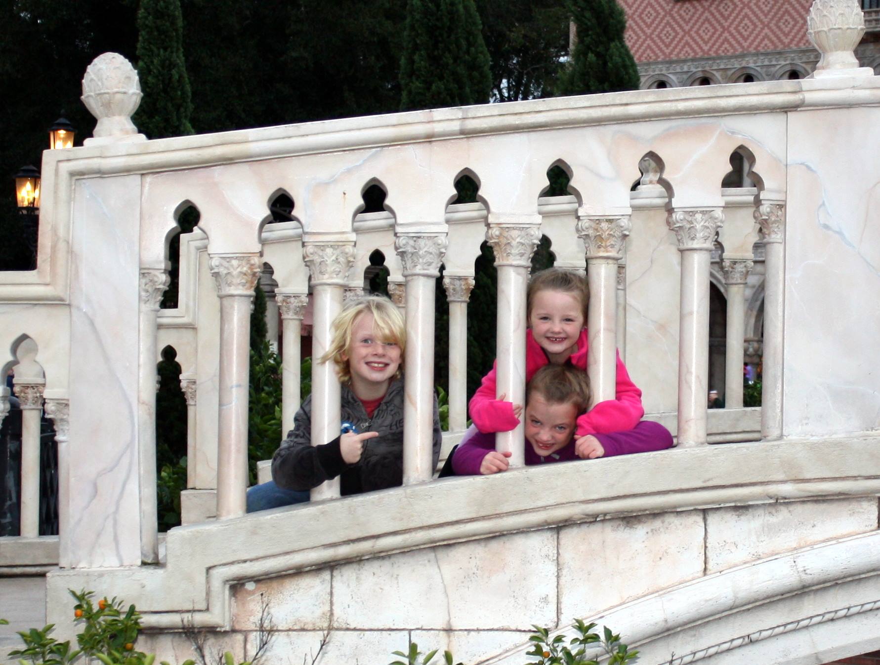 Kids leaning on stone bridge